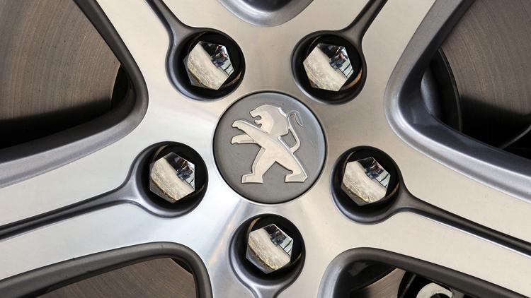 Logo de Peugeot sur la roue d'un véhicule [Alain Jocard / AFP/Archives]