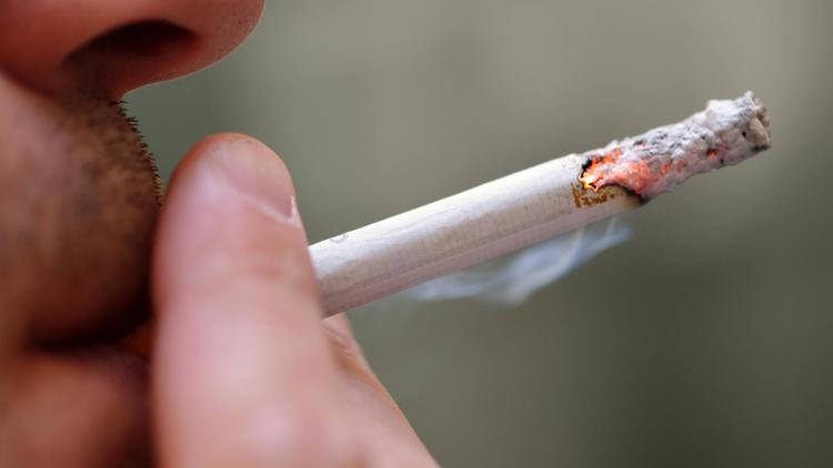 Un homme fume une cigarette [Eric Feferberg / AFP/Archives]