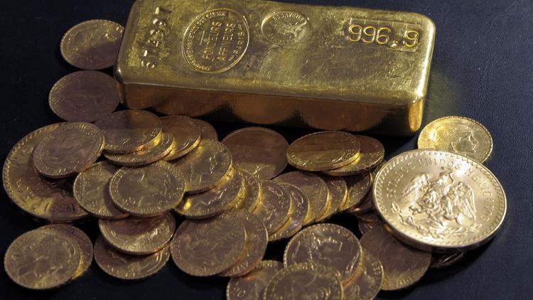 Un lingot et des pièces d'or [Bertrand Guay / AFP]