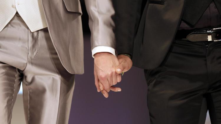 Deux mannequins hommes se tiennent la main lors d'un défilé au salon du mariage à Paris, en octobre 2012 [Kenzo Tribouillard / AFP/Archives]