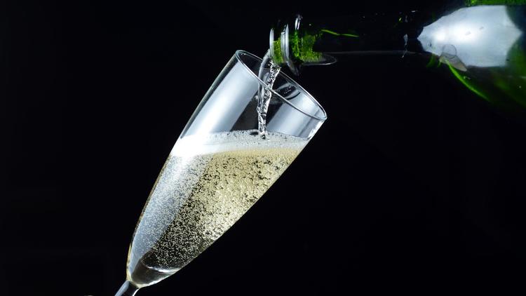 Une personne sert du champagne dans une coupe [Miguel Medina / AFP/Archives]