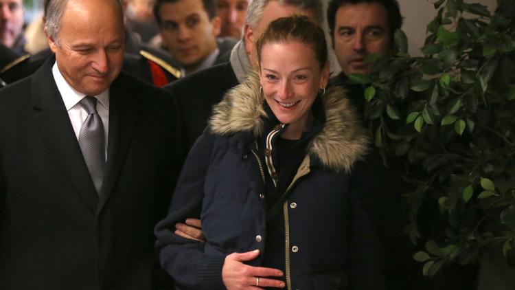 Florence Cassez accompagnée de Laurent Fabius, ministre des Affaires étrangères, lors de son arrivée à l'aéroport de Roissy, le 24 janvier 2013 [Thomas Samson / AFP]