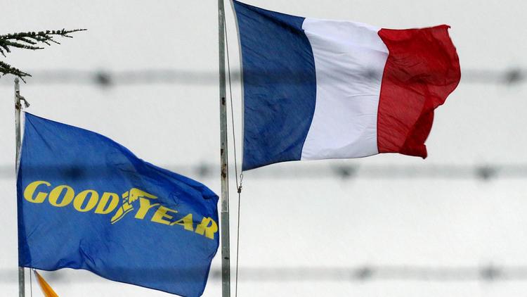 Un drapeau de l'entreprise Goodyear à côté d'un drapeau français, à l'entrée de l'usine d'Amiens, en janvier 2013 [Francois Nascimbeni / AFP/Archives]