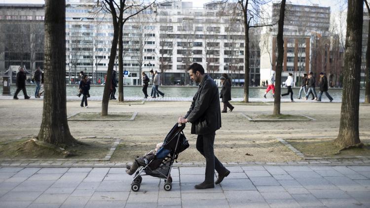Un père promène son enfant dans une poussette à Paris le 10 février 2013