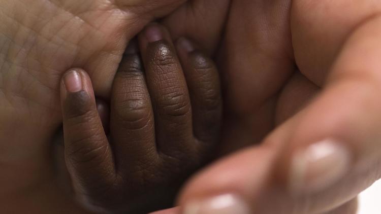 Une femme tient la main d'un bébé [Joel Saget / AFP/Archives]