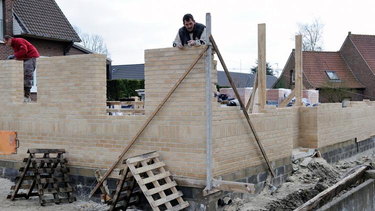 Des ouvriers du bâtiment montent un mur, le 21 mars 2013 à Grande-Synthe, dans le nord de la France [Philippe Huguen / AFP/Archives]