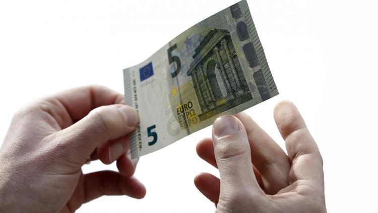 Un homme tient un billet de 5 euros, nouvelle version [Bas Czerwinski / ANP/AFP/Archives]