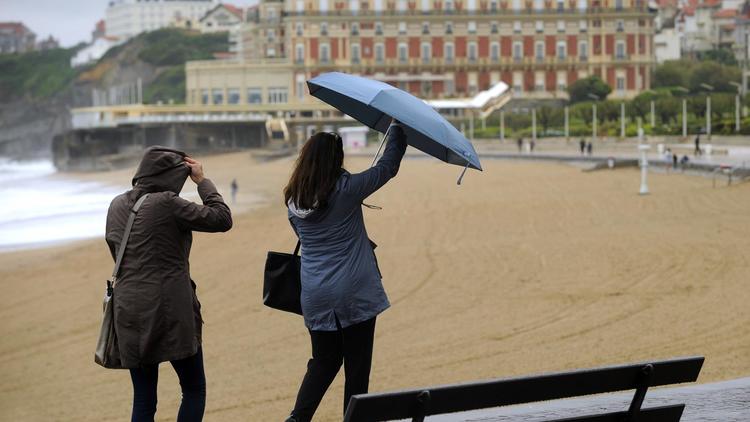 Des touristes essaient de se protéger de la pluie à Biarritz, le 21 mai 2013 [Gaizka Iroz / AFP]