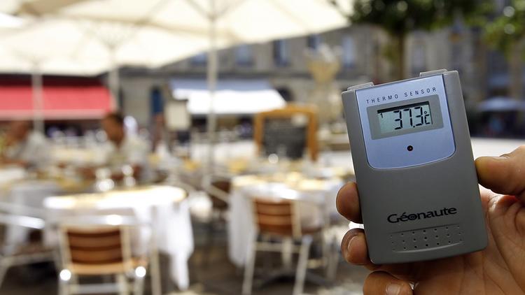 Un restaurateur relève a l'aide d'un thermomètre la température sur la terrasse de son établissement, le 17 juillet 2006 à Bordeaux, [Patrick Bernard / AFP/Archives]