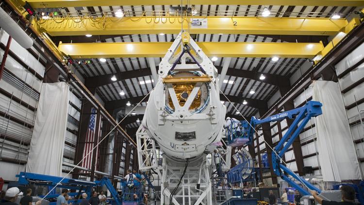 Photo de la NASA publiée le 5 octobre 2012 montrant des techniciens qui fixent la capsule Dragon à la fusée Falcon 9 depuis la base aérienne de Cap Canaveral, en Floride, le 5 octobre 2012 [ / Nasa/AFP/Archives]