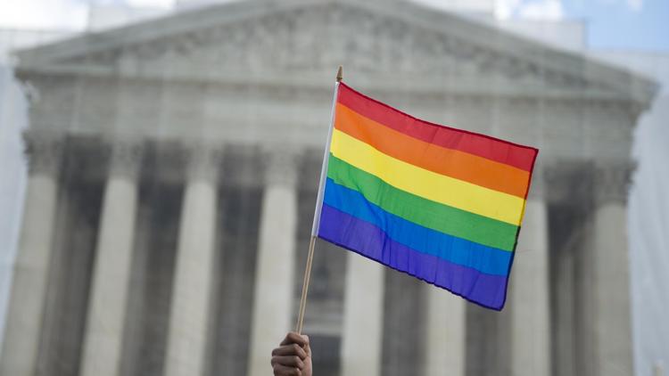 Un pro-mariage gay lève un drapeau arc-en-ciel devant la Cour suprême des Etats-Unis, le 26 mars 2013 à Washington [Saul Loeb / AFP/Archives]