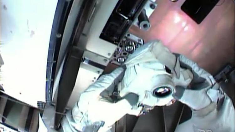 Sur cette photo fournie par Nasa TV le 11 mai 2013, Chris Cassidy photographie les éléments de l'ISS à réparer [ / Nasa TV/AFP]