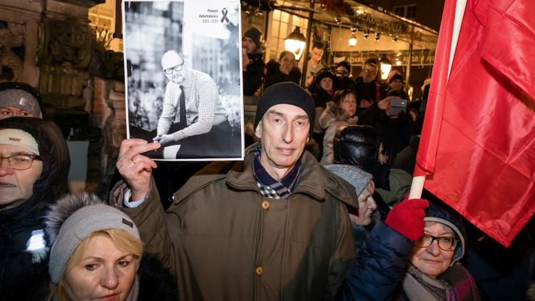Un homme brandit une photo du maire de Gdansk lors des obsèques de Pawel Adamowicz, le 18 janvier 2019 à Gdansk [Wojtek RADWANSKI / AFP]