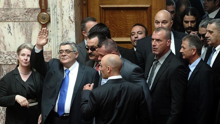 le dirigeant du parti néonazi Aube dorée Nikos Michaloliakos (bras levé) le 17 mai 2012 au Parlement à Athènes [Aris Messinis / AFP/Archives]