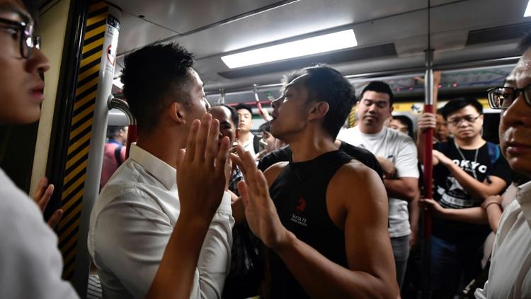Des manifestants essaient de bloquer une rame de métro, le 5 août 2019 à Hong Kong [Anthony WALLACE / AFP]