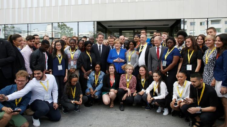 Emmanuel Macron et Angela Merkel posent avec des étudiants lors d'une visite de l'Office franco-allemand de la Jeunesse, le 13 juillet 2017 [Matthieu Alexandre / POOL/AFP]