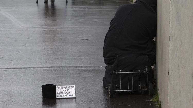 Un SDF fait la mendicité "pour manger" dans une rue de Paris le 19 février 2014 [Joel Saget / AFP]