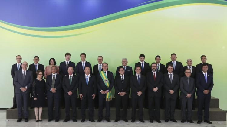 Le président brésilien Jair Bolsonaro, ceint de l'écharpe présidentielle, entouré de ses ministres, au palais du Planalto à Brasilia, le 1er janvier 2019 [Sergio LIMA / AFP]
