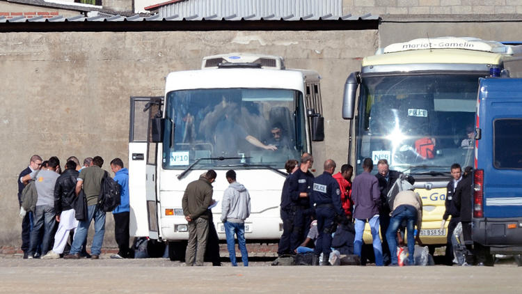 Des policiers français conduisent des clandestins expulsés de leur camp à Calais pour les amener dans un centre de rétention, le 2 juillet 2014 [Denis Charlet / AFP/Archives]
