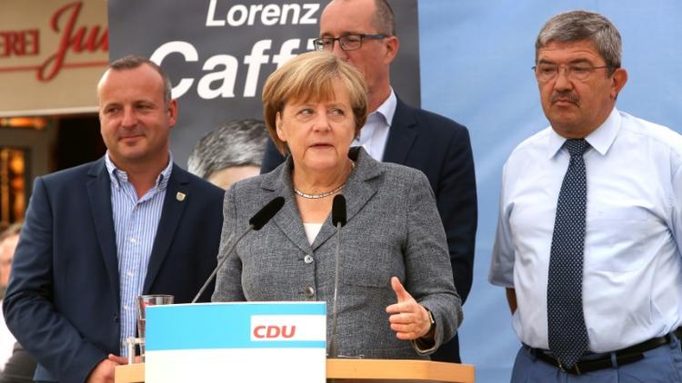 La chancelière allemande Angela Merkel à côté du ministre de l'Intérieur de Mecklembourg-Poméranie occidentale Lorenz Caffier (droite) et le candidat de la CDU Christian Democratic, lors d'un meeting de campagne à Bad Doberan (est), le 3 septembre 2016 [Adam BERRY / AFP]