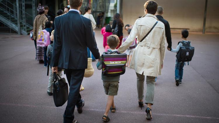 Des parents accompagnent leur fils à l'école le jour de la rentrée scolaire le 3 septembre 2013 à Paris [Martin Bureau / AFP/Archives]