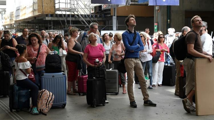 Les voyageurs patientent dans les halls de la gare Montparnasse à Paris, le 28 juillet 2018 [Bertrand GUAY / AFP]