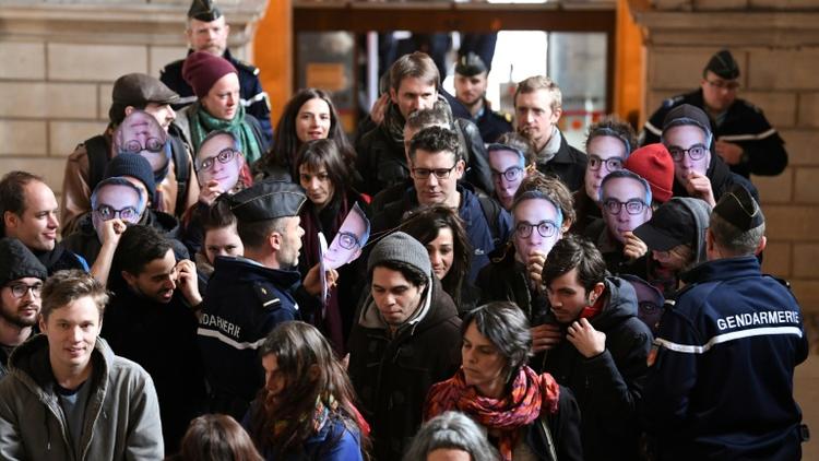 Des prévenus portant un masque de Julien Coupat arrivent au tribunal correctionnel de Paris pour l'ouverture du procès du "groupe de Tarnac", le 13 mars 2018 [ALAIN JOCARD / AFP]