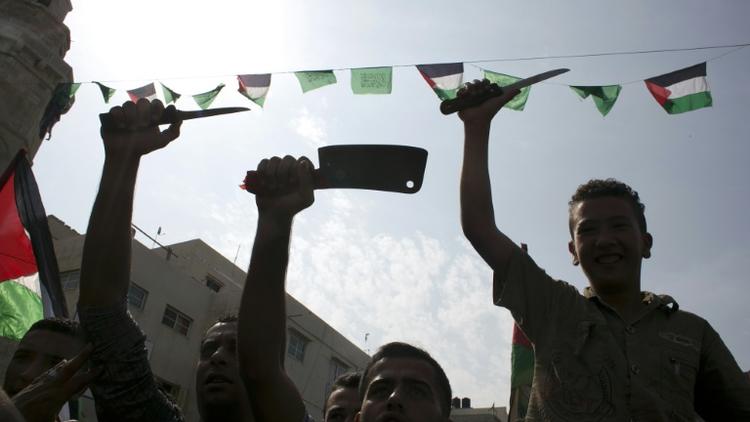 Des étudiants palestiniens brandissent des couteaux en guise de menaces contre les Israéliens, le 18 octobre 2015 à Khan Yunis, dans la bande de Gaza [SAID KHATIB / AFP]