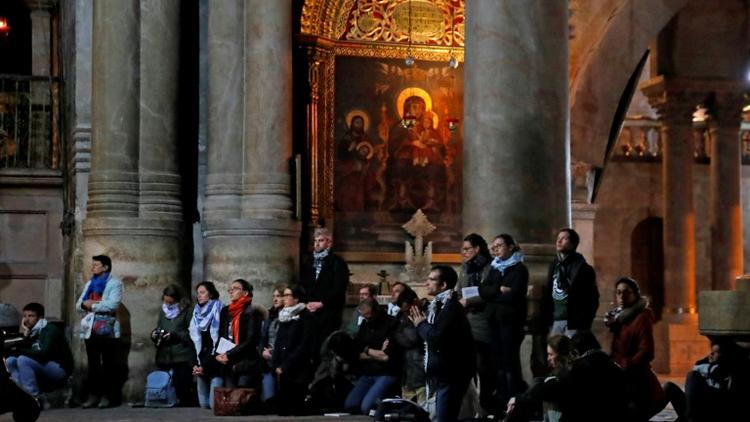 Des fidèles prient dans l'église de Saint-Sépulcre, à Jérusalem, rouverte le 28 février 2018 après trois jours de fermeture [THOMAS COEX / AFP]