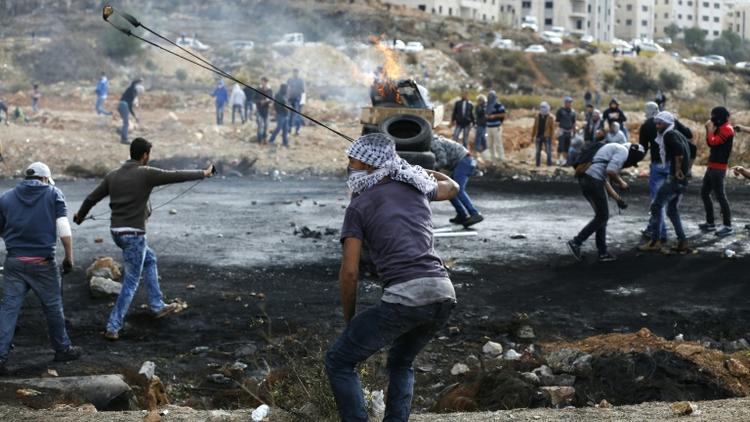 Des Palestiniens lancent des pierres vers des soldats israéliens dans les environs de Ramallah, le 27 octobre 2015 [ABBAS MOMANI / AFP/Archives]
