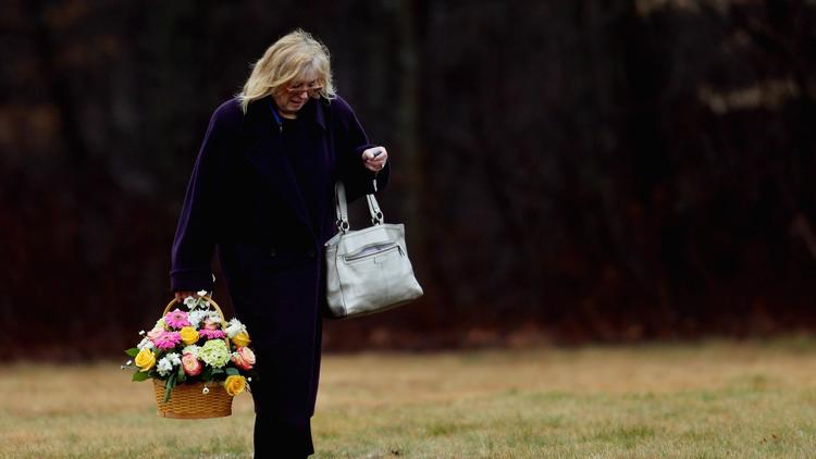 Une femme apporte des fleurs pour les funérailles d'un enfant décédé dans la tuerie de Newtown, le 17 décembre 2012 à Monroe [Spencer Platt / AFP/Getty Images]