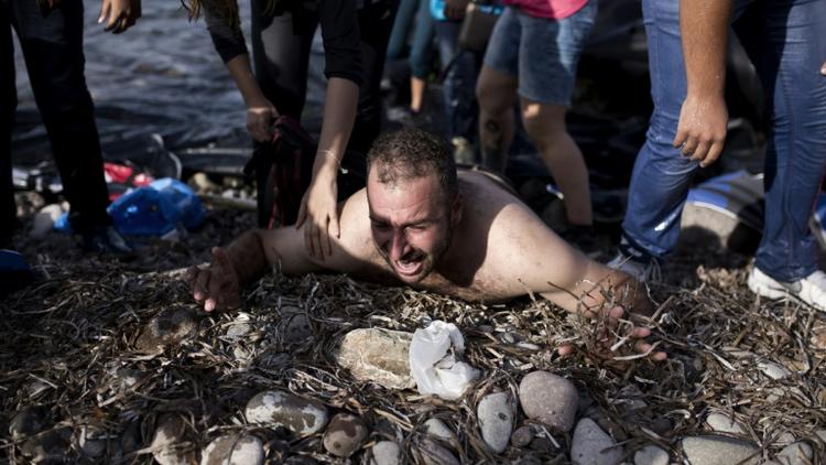 Un migrant hurle à son arrivée le 10 septembre sur le rivage de l'île de Lesbos en Grèce [ANGELOS TZORTZINIS / AFP]