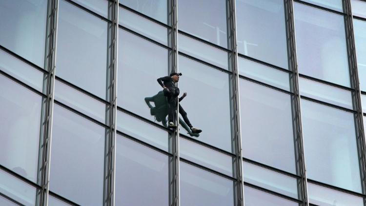 Le grimpeur urbain français Alain Robert, surnommé le "Spiderman français", au cours de son escalade du Skyper, une tour de 42 étages à Francfort, en Allemagne, le 28 septembre 2019 [Daniel ROLAND / AFP]