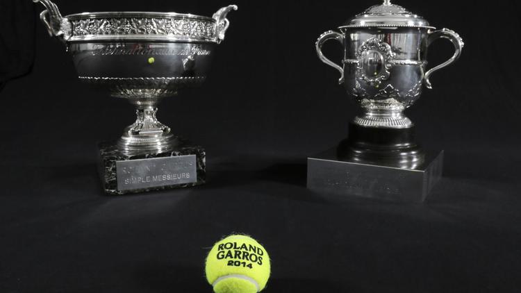 La Coupe des Mousquetaires (d) et la Coupe Suzanne Lenglen, récompensant les vainqueurs des simples messieurs et dames du tournoi de Roland-Garros, photographiés le 18 novembre 2013 à Paris [Jacques Demarthon / AFP/Archives]