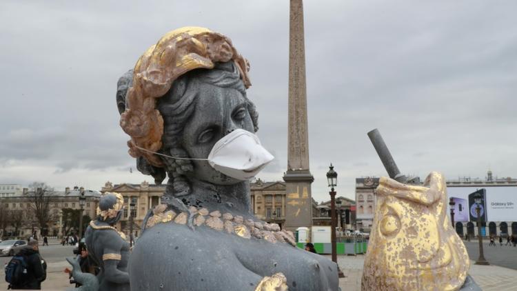 Des masques protecteurs ont été apposés le 31 mars 2018 devant la bouche de statues place de la Concorde, afin de dénoncer l'inaction des pouvoirs publics contre la pollution de l'air [JACQUES DEMARTHON / AFP]