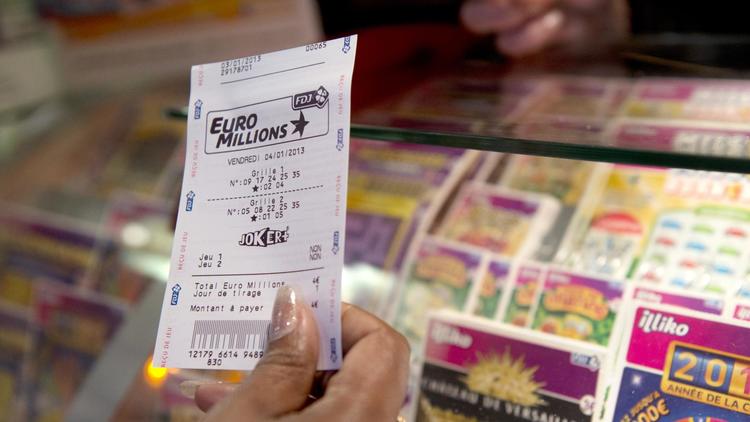 Un joueur tient un ticket d'Euro Millions à la main [Miguel Medina / AFP/Archives]