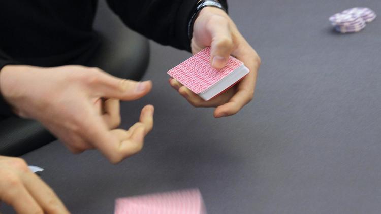 Un croupier bat les cartes à une table de poker [Valery Hache / AFP/Archives]