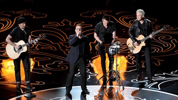 Le chanteur Bono accompagné de ses musiciencds dont The Edge (g), lors d'une représentation aux Oscars, le 2 mars 2014  [Kevin Winter / Getty Images/AFP/Archives]