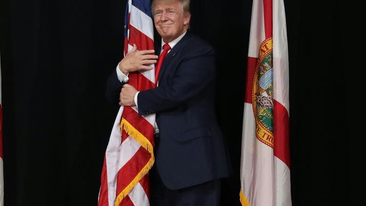 Donald Trump enlace le drapeau américain, le 24 octobre 2016 à Tampa (Floride) [JOE RAEDLE / GETTY IMAGES NORTH AMERICA/AFP/Archives]