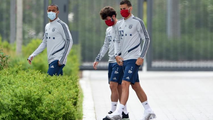 Les joueurs du Bayern Munich Thiago Alcantara, Alvaro Odriozola et Lucas Hernandez portent un masque à leur arrivée à l'entraînement le 13 mai à Munich [Christof STACHE / AFP]