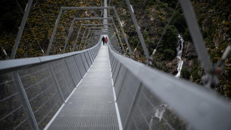 Les gens traversent pour la première fois, le 29 avril 2021, le pont pédestre suspendu le plus long du monde (516 m) à 175 m au-dessus de la rivière Paiva dans le nord du Portugal [CARLOS COSTA / AFP]