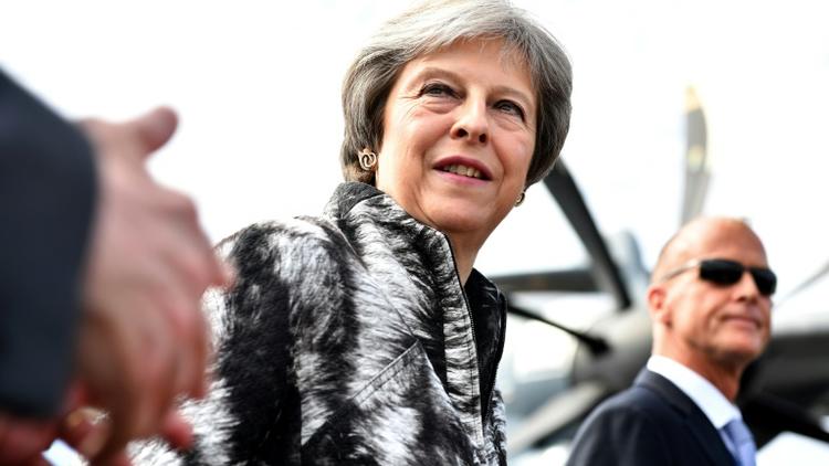 La Première ministre britannique Theresa May (c) arrive au salon de Farnborough, dans le sud-ouest de Londres, accompagnée du patron d'Airbus Tom Enders (d), le 16 juillet 2018 [Ben STANSALL / AFP]