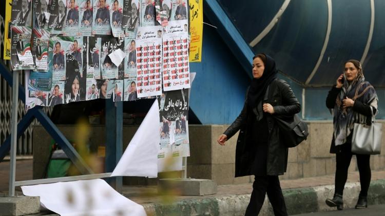Des Iraniennes circulant dans une rue de Téhéran devant des affiches électorales le 19 février 2020 [ATTA KENARE / AFP]