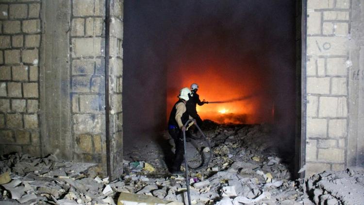 Des Casques blancs, une organisation de secouristes en zone rebelle, luttent contre un incendie après des frappes aériennes sur la ville d'Idleb, le 24 mars 2017 en Syrie [Omar haj kadour / AFP/Archives]