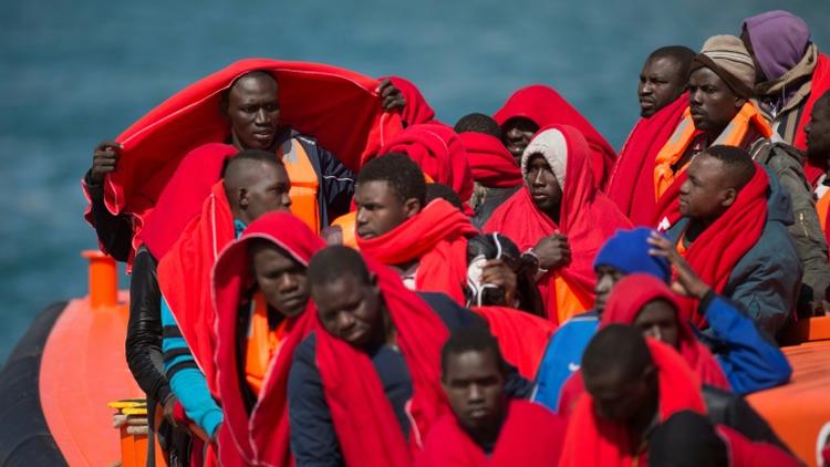 Des migrants enveloppés de couvertures fournies par la Croix-Rouge arrivent à Malaga (Espagne) à bord d'un navire de garde-côtes espagnols qui les a secourus sur leur canot gonflable, le 9 juin 2018 [JORGE GUERRERO / AFP/Archives]