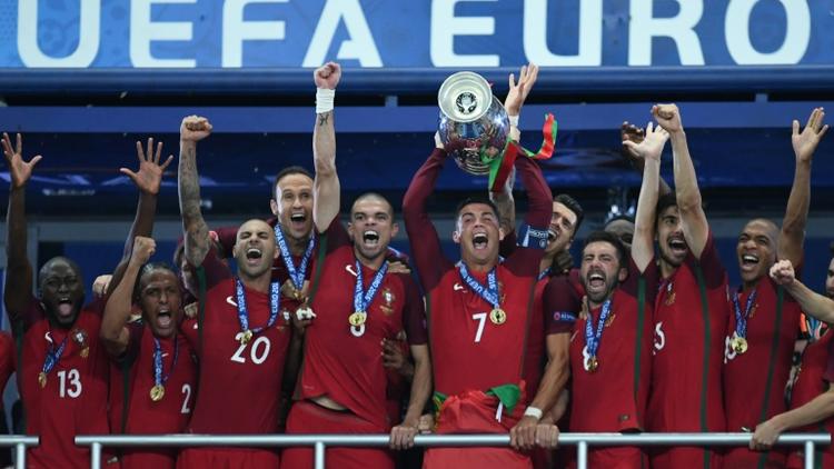 L'attaquant vedette du Portugal Cristiano Ronaldo (c) brandit le trophée entouré des ses équipiers après la victoire face à la France en finale de l'Euro au Stade de France, le 10 juillet 2016  [FRANCISCO LEONG / AFP]