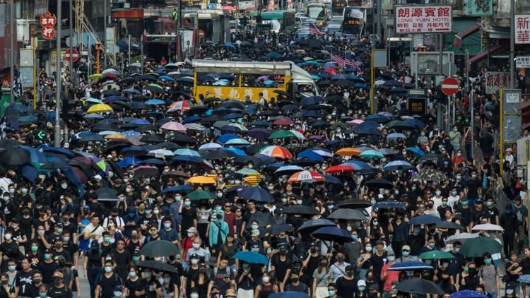 Des milliers de manifestants marchent dans l'artère principale du quartier de Mong Kok, le 20 octobre 2019 à Hong Kong [Philip FONG / AFP]