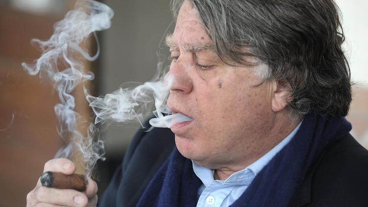 Gilbert Collard, un élu du parti d'extrême droite Front National (FN) fumant un cigare après son vote pour le deuxième tour des élections municipales le 30 mars 2014, à Saint-Gilles, dans le sud de la France [Pascal Guyot / AFP/Archives]