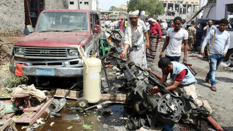 Le 13 mars 2018 à Aden au Yémen, des yéménites inspectent l'épave d'une voiture détruite par l'attentat suicide [SALEH AL-OBEIDI / AFP]
