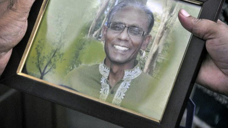 Un homme montre le portrait du professeur Rezaul Karim Siddique, à Rajshahi, le 23 avril 2016 [MD. ABDULLAH IQBAL / AFP]